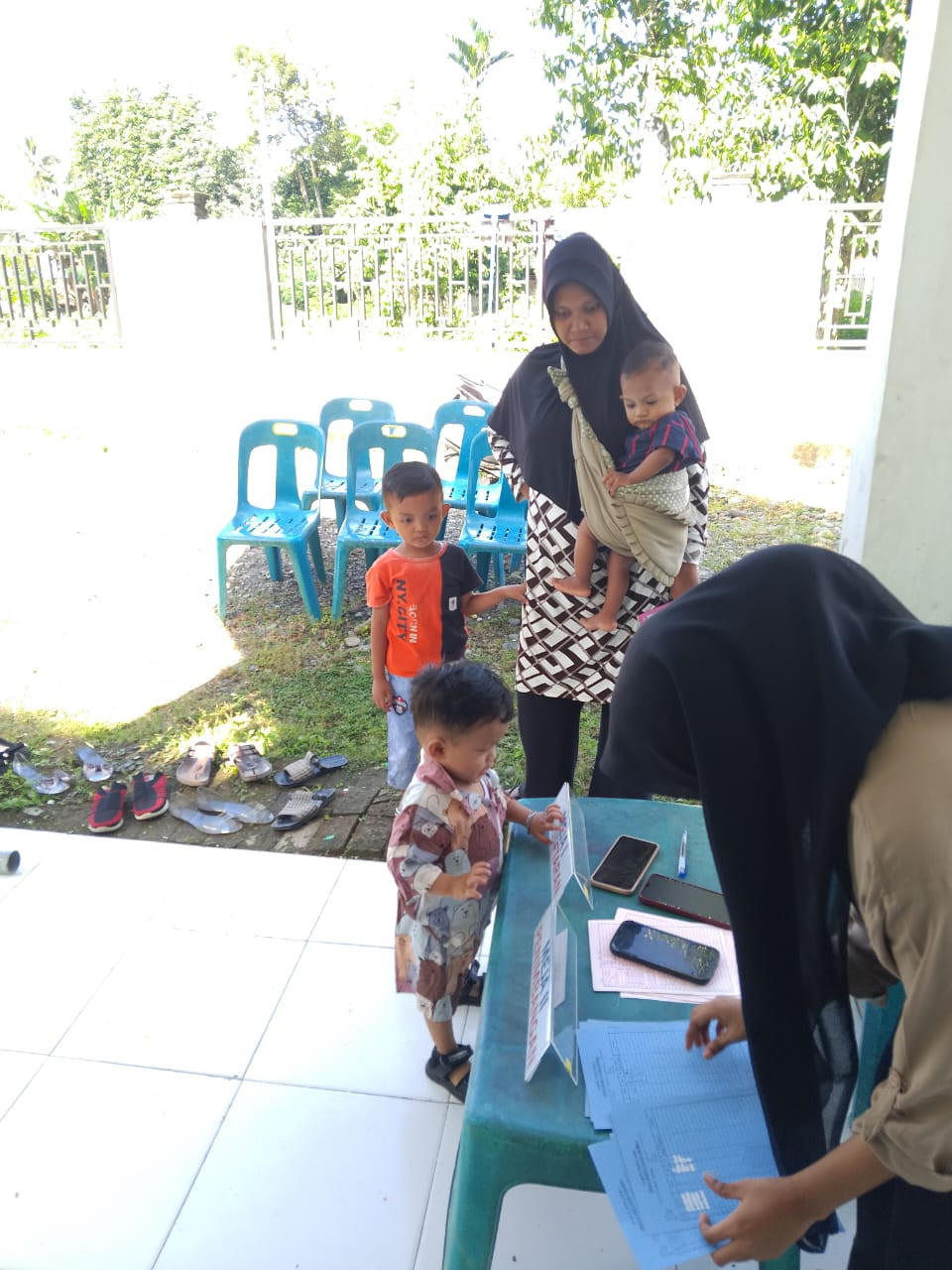 Kader Posyandu Mengecek Arsip data Balita dan Ibu Hamil.