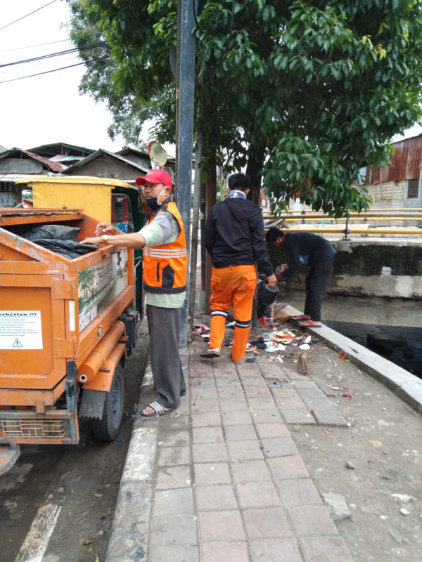 menindak pemulung memilah sampah di pinggir kali kelurahan Utan Kayu Selatan