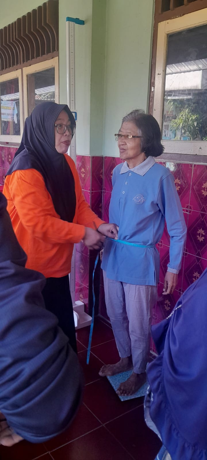 kader sedang mengukur lingkar perut