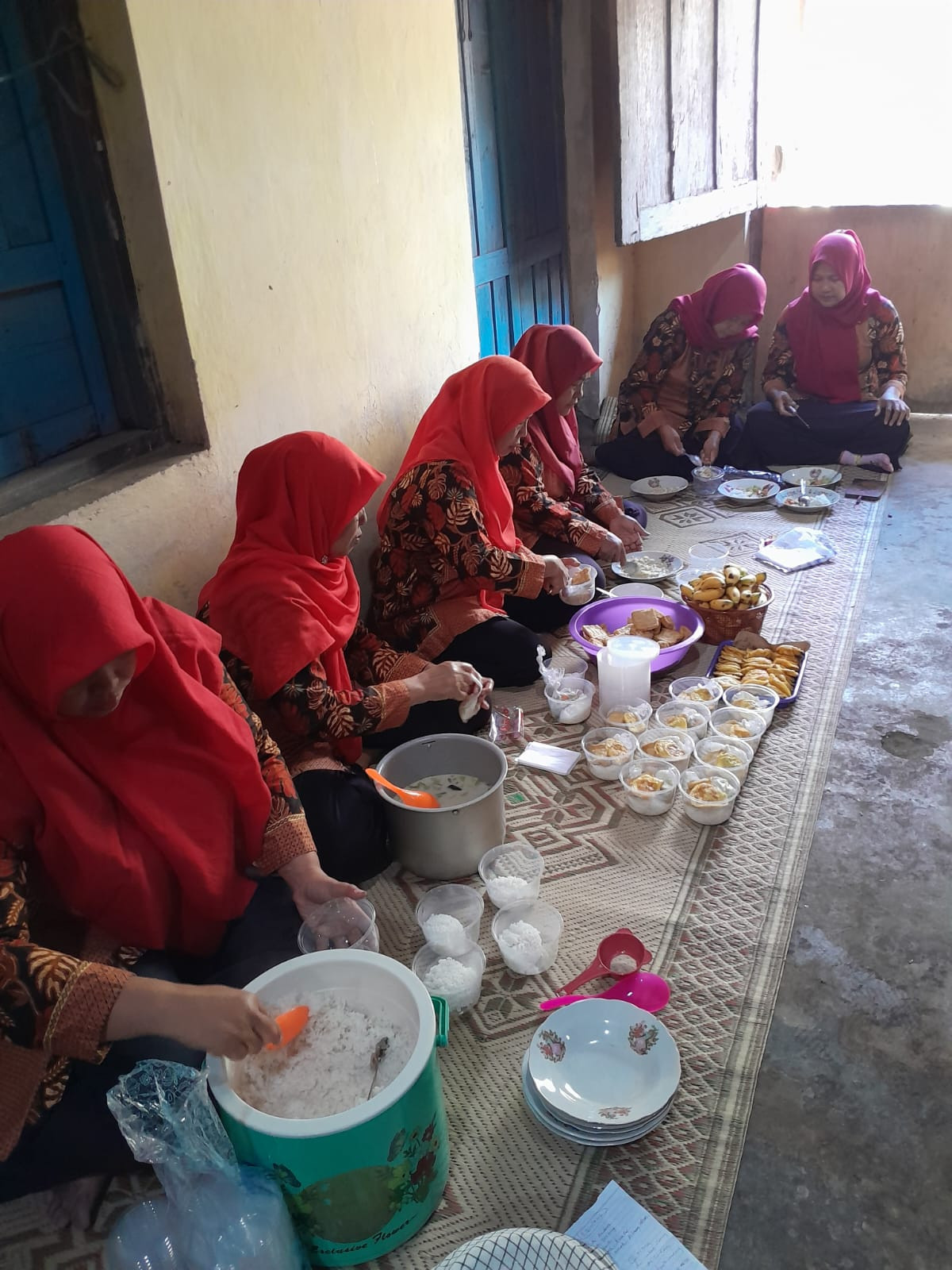 Ibu-ibu kader yang sedang mempersiapkan makanan tambahan yang akan dibagikan