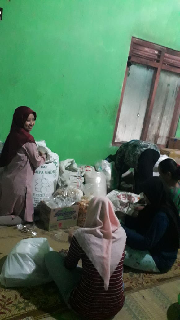 Sebagian ibu-ibu ada yang membungkus beras untuk persiapan acara 7 harian