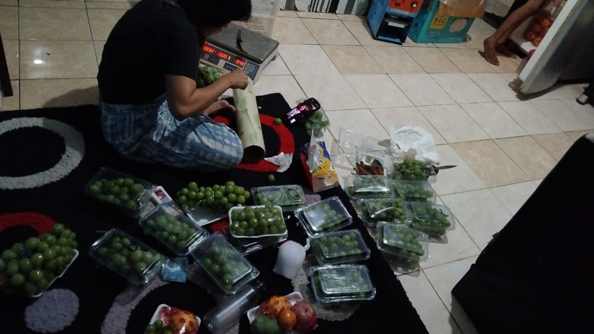 Kegiatan pengemasan buah2an persiapan bazar oleh Ibu Muslimah di Padukuhan Malangrejo