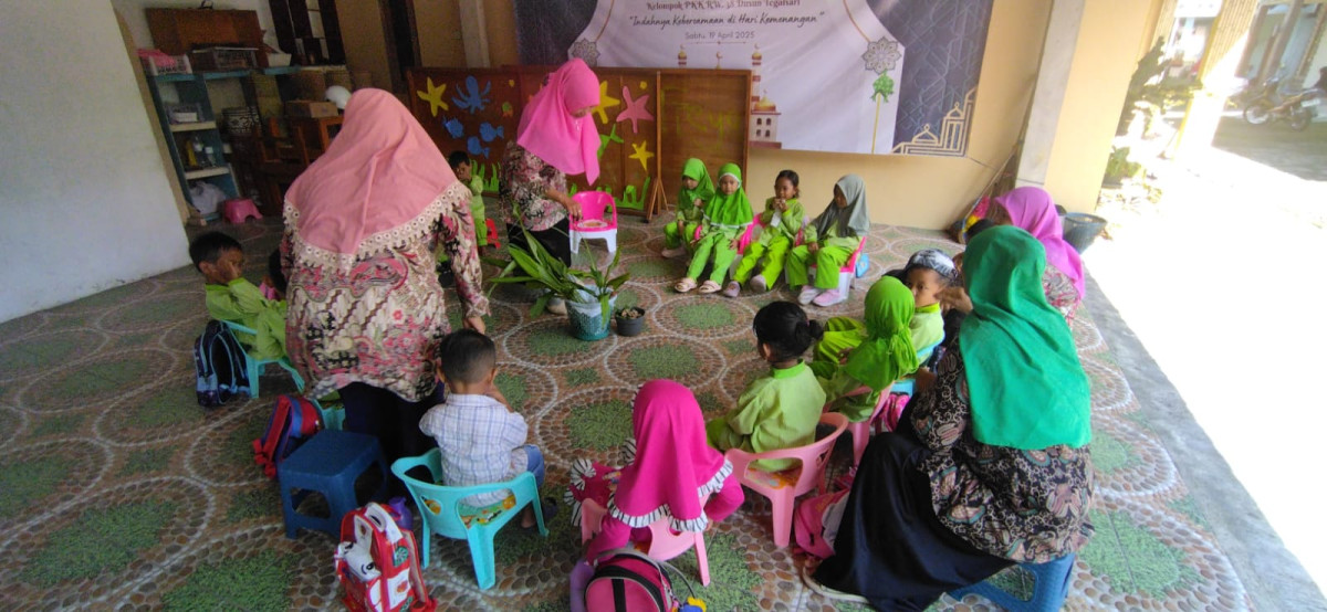 Bunda guru memegang jahe, kunyit dan kencur untuk di perlihatkan oleh anak anak supaya bisa membedakan bentuk, warna dan rasa