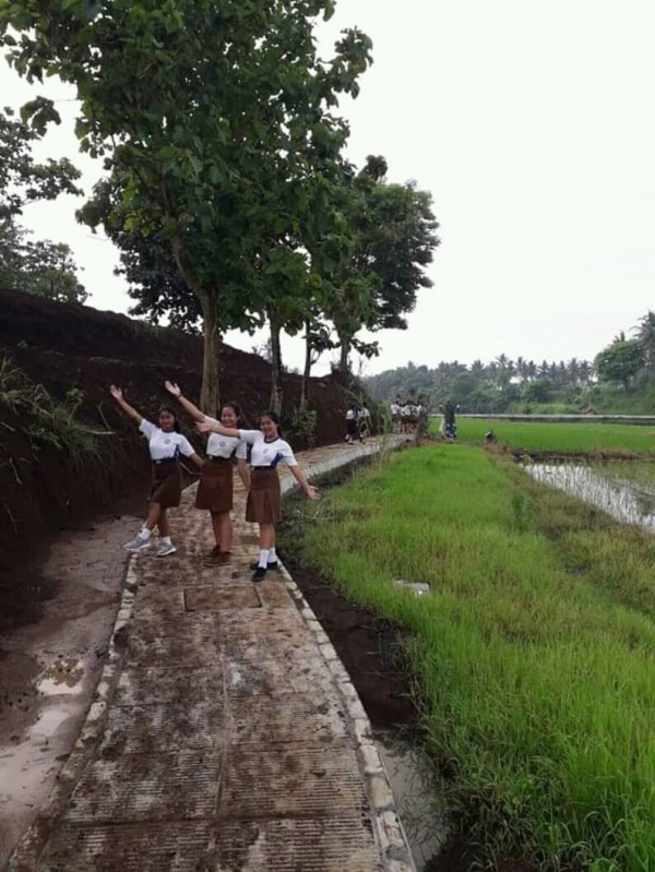 Murid SMP Swadyaya Desa Penarungan sedang berjalan santai