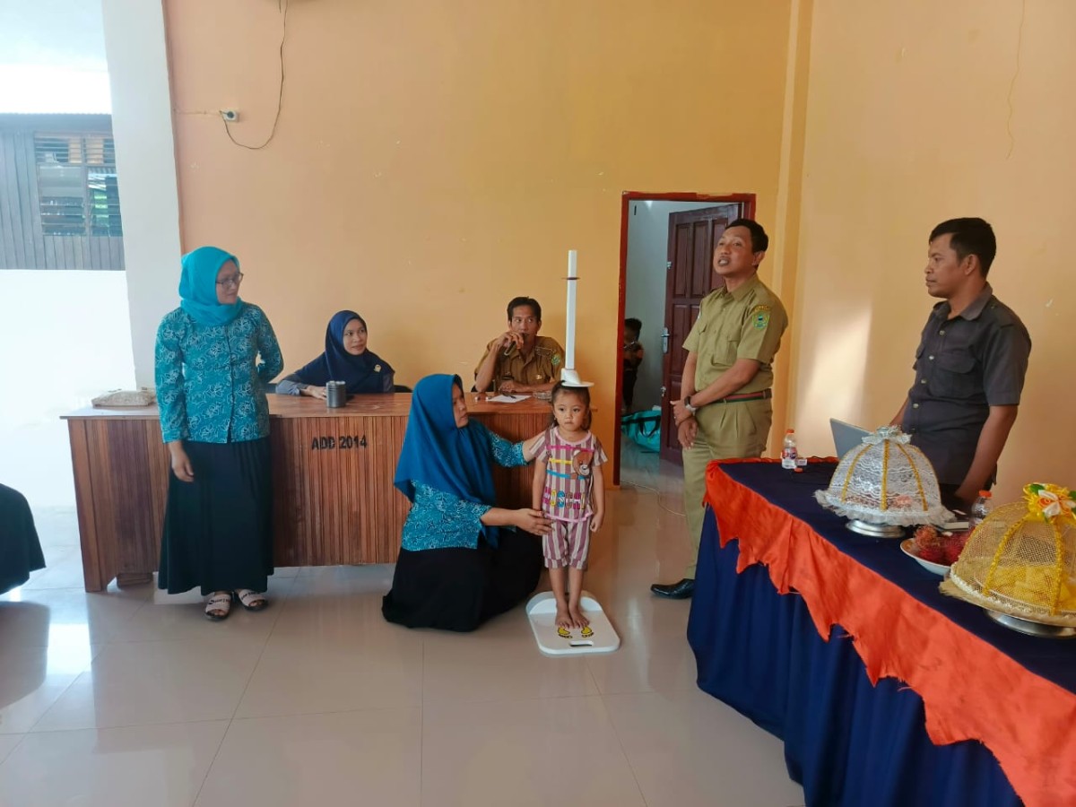 Petugas Kesehatan memberikan penjelasan pada kader posyandu terkait cara mengukur TB dan BB anak Balita dengan baik dan benar